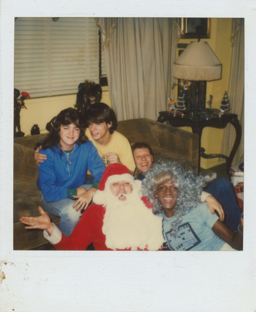 Download the full-sized image of A Photograph of Marsha P. Johnson Wearing Tinsel on Her Head, Posing with "Santa," and Others