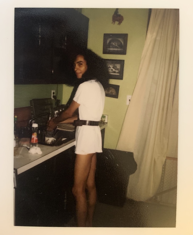 Download the full-sized image of A photograph of Malú Rivera Standing at a Sink in a White Dress