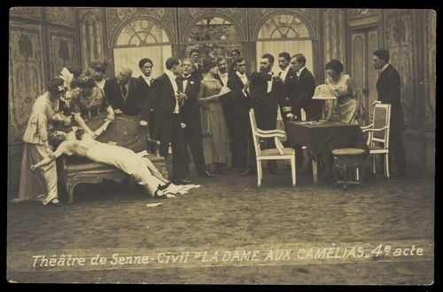 Download the full-sized image of French or Belgian prisoners of war, some in drag, posing on stage during a crowded scene of "La dame aux camélias"; at Sennelager prisoner of war camp in Germany. Photographic postcard, 191-.